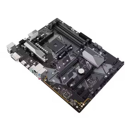 Top angled view of the ASUS PRIME B450-PLUS motherboard highlighting the AM4 socket, four DDR4 DIMM slots, SATA ports, PCIe slots, M.2 storage support, and premium black-and-silver styling.