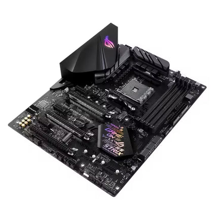 A black ASUS ROG Strix B450-F motherboard with integrated RGB lighting on the VRM chips and a large black heatsink, shown from an elevated angle on a white background.