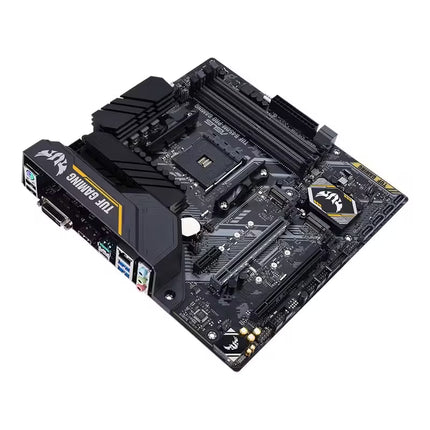 Low-angle perspective of the ASUS TUF Gaming B450M-PRO motherboard, displaying the AM4 socket, four DDR4 memory slots, PCIe expansion slots, heatsinks, chipset cover, and rear I/O section with TUF Gaming branding.