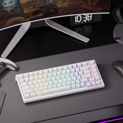 White mechanical keyboard with RGB lighting on a desk with a monitor and gaming accessories.