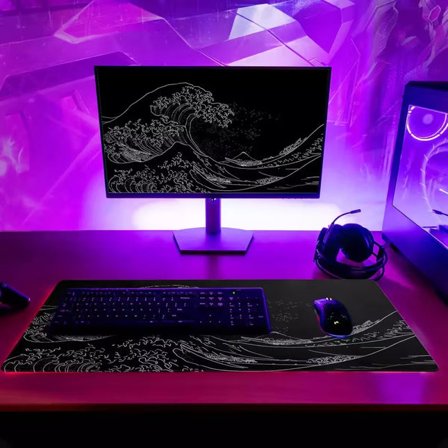 Modern desk setup with computer monitor, keyboard, mouse, and headphones under purple LED lights.