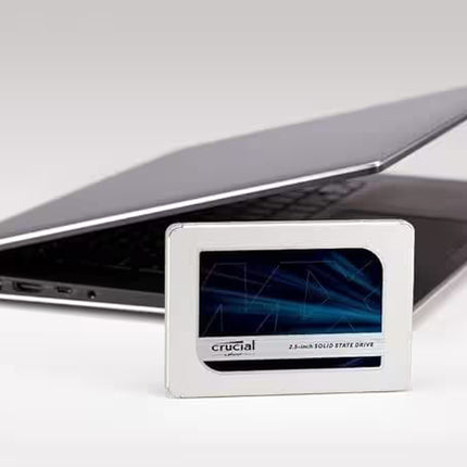 Crucial solid-state drive in front of a laptop on a white background