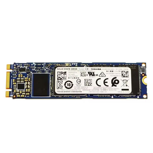 Front view of a Toshiba 256GB M.2 2280 SATA solid-state drive (SSD) with a blue PCB, visible NAND flash chip, and a white product label displaying model information, certification logos, and QR codes. The M.2 edge connector and mounting hole are visible against a white background.
