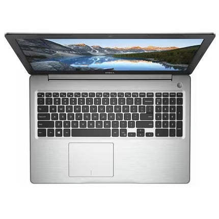 A silver and black laptop shown from a top-down angle with the screen open, displaying a mountain lake landscape wallpaper. The brand name 'DELL' is visible in small white text on the bezel below the screen.