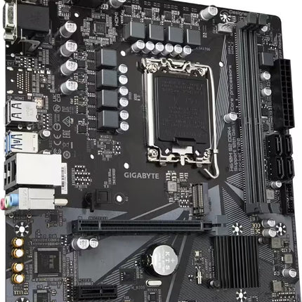 Angled, close-up perspective view looking down from the top-left corner of a Gigabyte H610M S2 DDR4 motherboard. The shot highlights the metallic rear I/O connectors on the left edge, the circular CR2032 CMOS battery near the PCIe slot, and the two vertical DDR4 RAM slots on the right