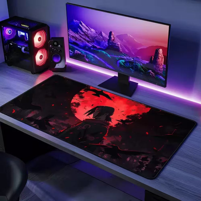 Gaming desk setup with monitor, speakers, and large mouse pad featuring a red and black design.
