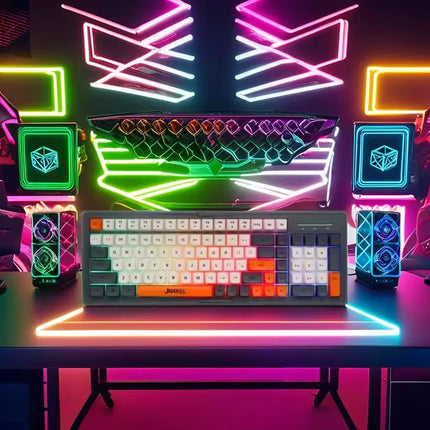 Gaming setup with a keyboard, monitor, and colorful neon lights on a desk.