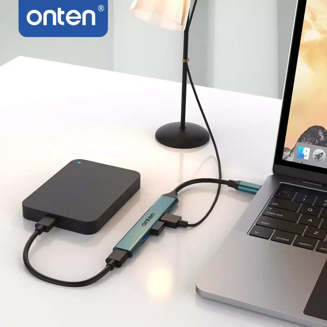 Laptop with external hard drive and adapter on a desk, featuring the 'onten' brand.