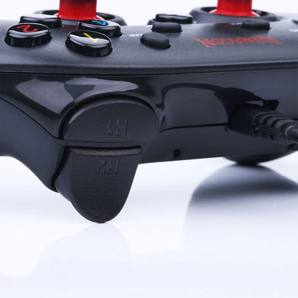 Close-up of a black gaming controller with buttons on a white background