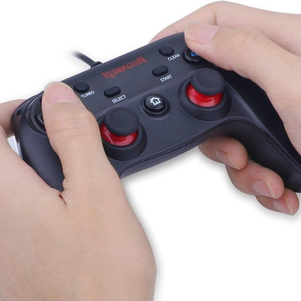 Game controller with red buttons held by hands on a white background