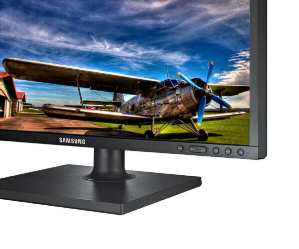 Samsung monitor displaying an image of a biplane on a grassy field with a blue sky.