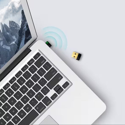 Laptop with wireless USB adapter on a light gray background