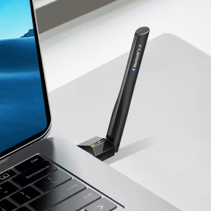 Black Bluetooth adapter on a laptop with a blue screen