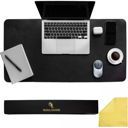 A black rectangular desk mat shown from above with a laptop, notebook, pen, phone, earbud case, coffee cup, and mouse placed on it. Below the desk mat are two branded accessories: a long black box labeled Trafal Leather and a yellow microfiber cloth.