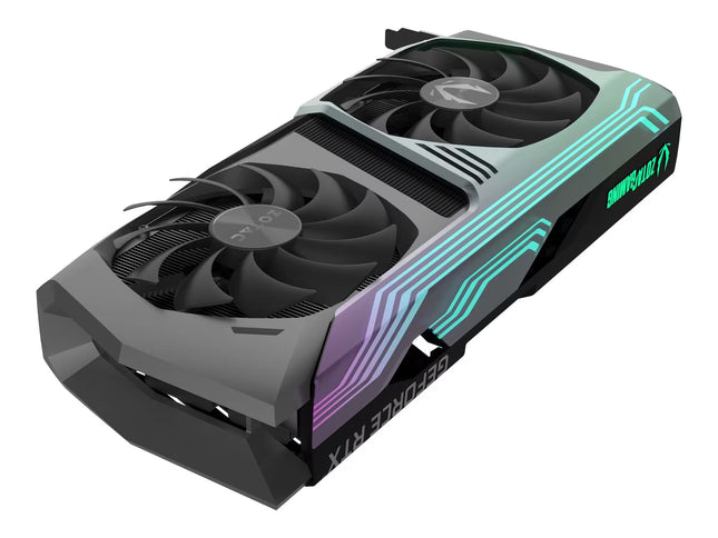 A Zotac graphics card with a black and dark gray dual-fan design, featuring green and purple RGB lighting accents on top, shown against a plain white background.