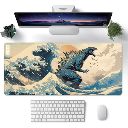 A large rectangular desk mat with a graphic print of Godzilla rising from a wave, styled on a white desk with a keyboard, mouse, and monitor.