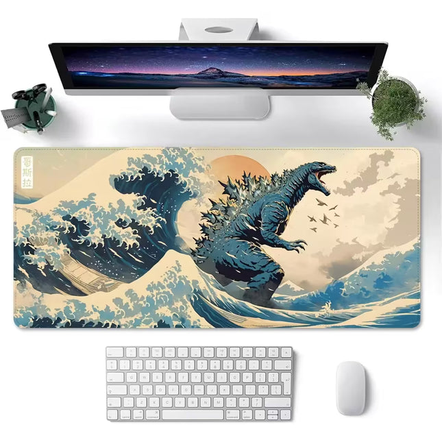 A large rectangular desk mat with a graphic print of Godzilla rising from a wave, styled on a white desk with a keyboard, mouse, and monitor.