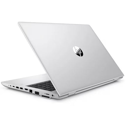Rear-angled view of a closed silver HP laptop resting on a white background, showcasing the circular HP logo in the center of the lid and an array of input/output ports along the left side profile.   