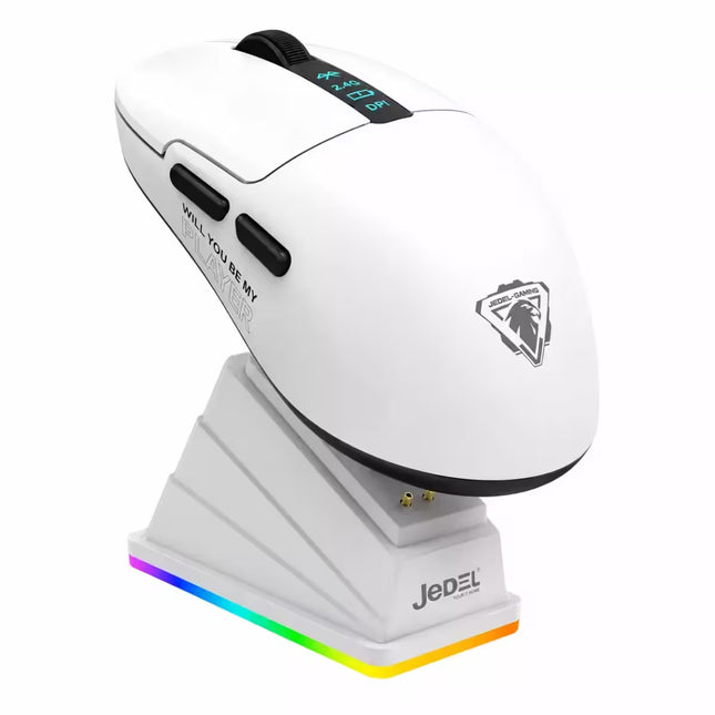 A white JEDEL wireless gaming mouse with black accents, resting on a matching white charging dock that features a multicolor RGB light strip. The mouse has a sleek ergonomic design with a black scroll wheel, side buttons, and a silver JEDEL logo on the side.