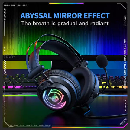 A black over-ear gaming headset with a boom microphone and RGB rainbow lighting on the ear cup, shown in front of a colorful monitor and keyboard setup with promotional text.