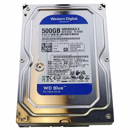 Top-down view of a Western Digital Blue 500GB 3.5-inch internal hard drive featuring a metallic silver casing, a central product label with blue branding, model and serial number details, barcodes, regulatory compliance icons, and electrical specifications.